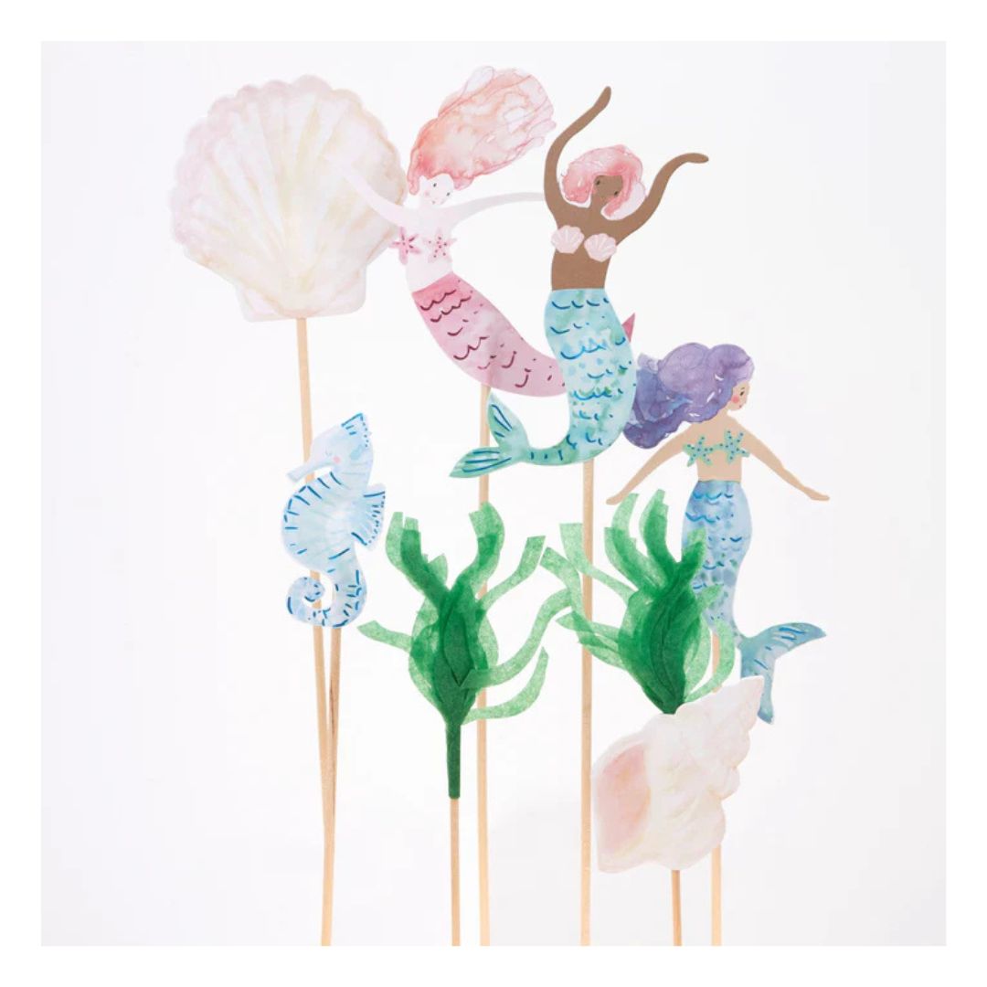 Mermaid-themed cake toppers with seashells, mermaids, and seahorses on sticks against a white background. - Remarkable Parties